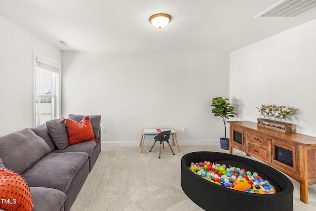 carpeted living area featuring visible vents and baseboards