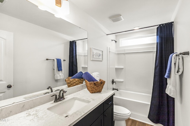 bathroom featuring visible vents, toilet, wood finished floors, shower / bathtub combination with curtain, and vanity