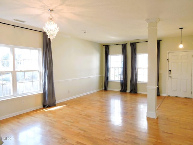 interior space featuring light wood finished floors, decorative columns, visible vents, and baseboards