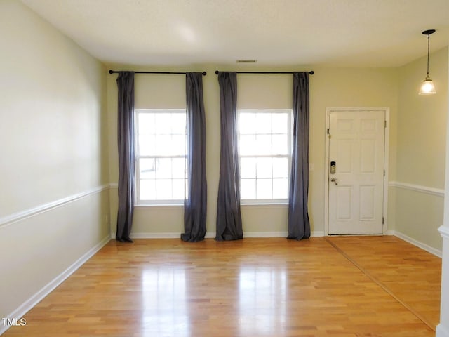 foyer featuring light wood-style floors and baseboards