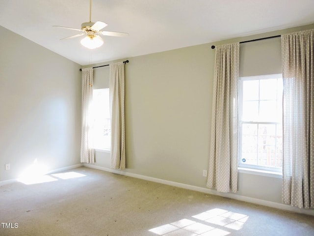 carpeted spare room featuring ceiling fan, baseboards, and a healthy amount of sunlight