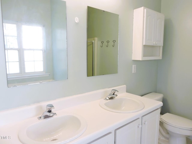 full bath featuring a shower with shower door, a sink, toilet, and double vanity