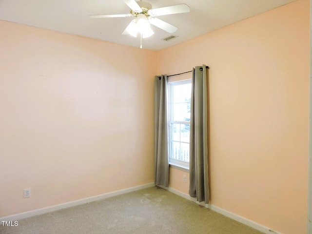 empty room with light carpet, a ceiling fan, visible vents, and baseboards