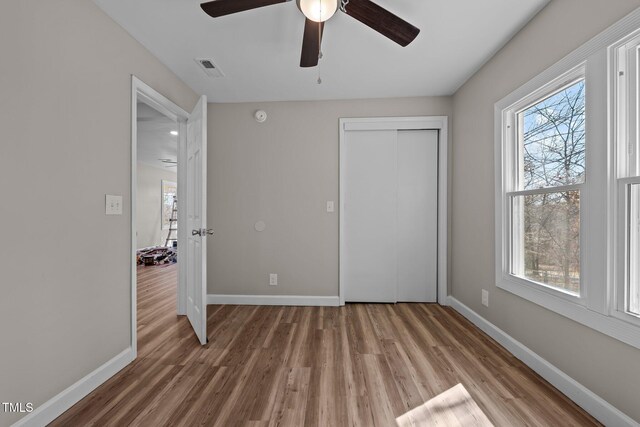 2810 Hickory Hill Rd, Burlington, NC 27215 - unfurnished bedroom featuring visible vents, multiple windows, baseboards, and wood finished floors