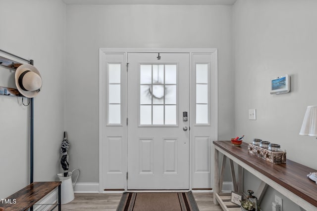 entryway with light wood-style flooring and baseboards