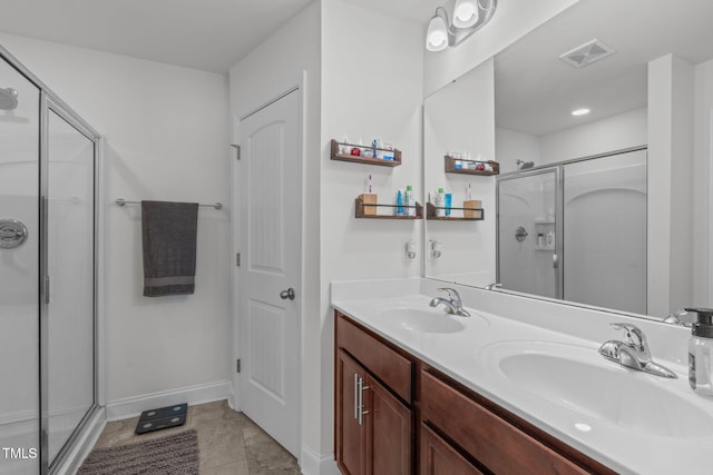 full bathroom with visible vents, a sink, a shower stall, and double vanity