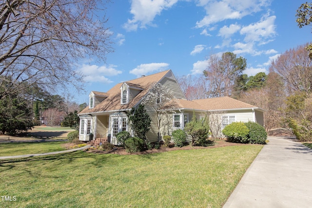 cape cod home featuring a front lawn