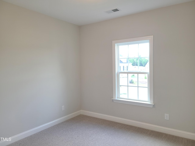 carpeted empty room featuring visible vents, plenty of natural light, and baseboards