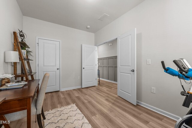 home office featuring baseboards and light wood finished floors