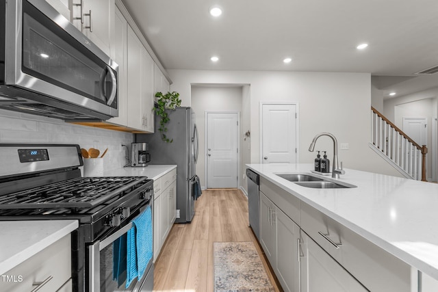 kitchen with a sink, stainless steel appliances, and light countertops