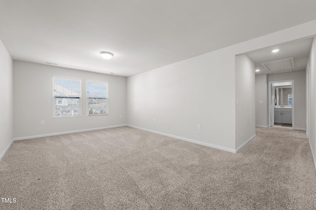 empty room featuring recessed lighting, light carpet, visible vents, baseboards, and attic access