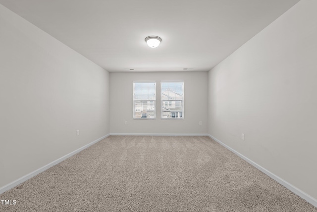 carpeted spare room featuring baseboards