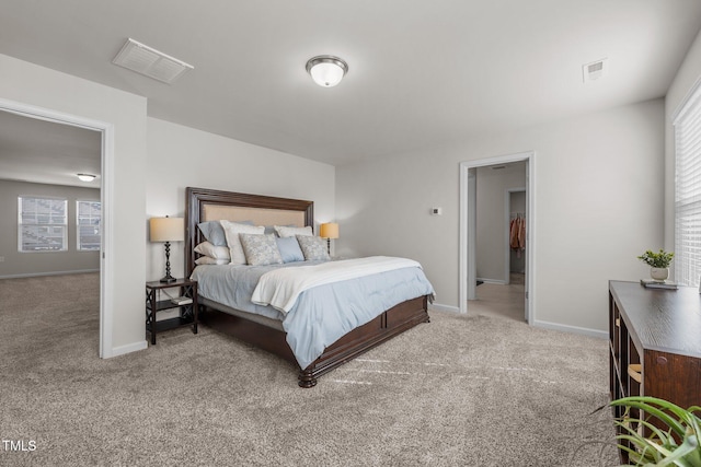 bedroom with light colored carpet, visible vents, and baseboards