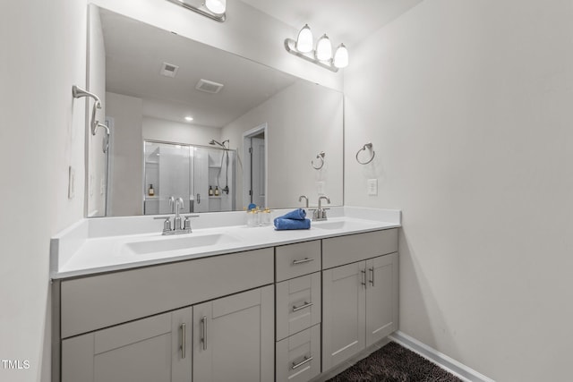 full bathroom with double vanity, a stall shower, a sink, and visible vents