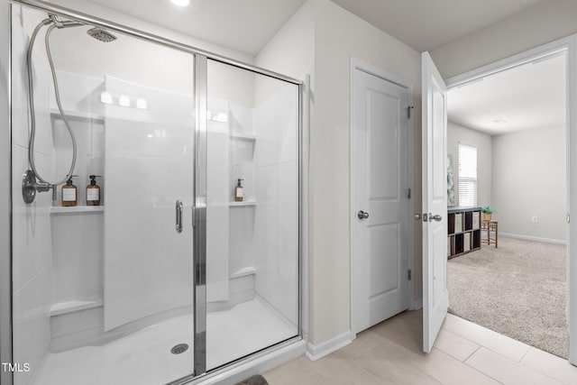 bathroom with a stall shower and baseboards