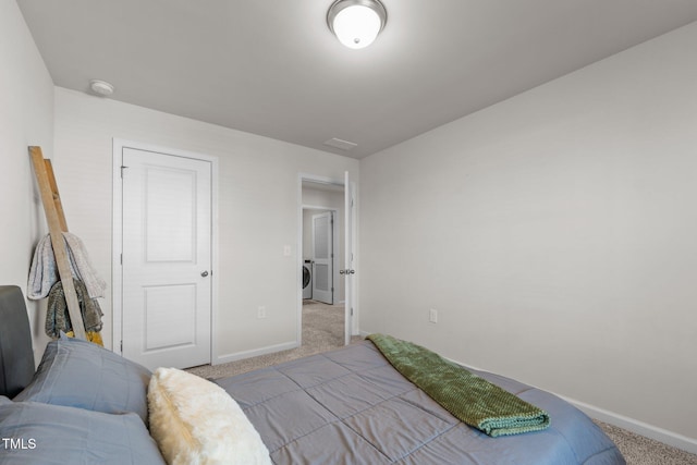 carpeted bedroom featuring washer / clothes dryer and baseboards