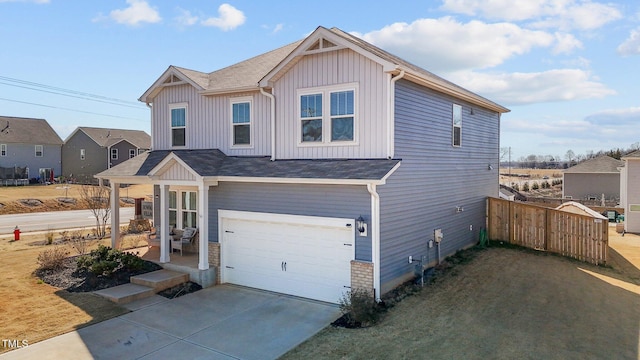 view of front facade with a garage, fence, board and batten siding, and concrete driveway