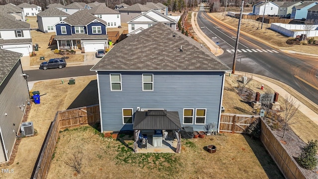 rear view of property with a patio, a fenced backyard, a residential view, a gazebo, and central AC