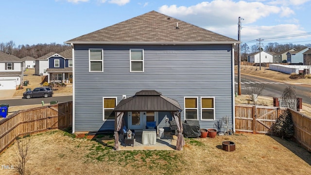 rear view of property with a lawn, a patio, a fenced backyard, a residential view, and a gazebo