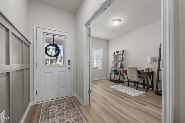 foyer entrance with light wood-style floors and baseboards