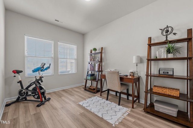 exercise area with light wood-type flooring, baseboards, and visible vents