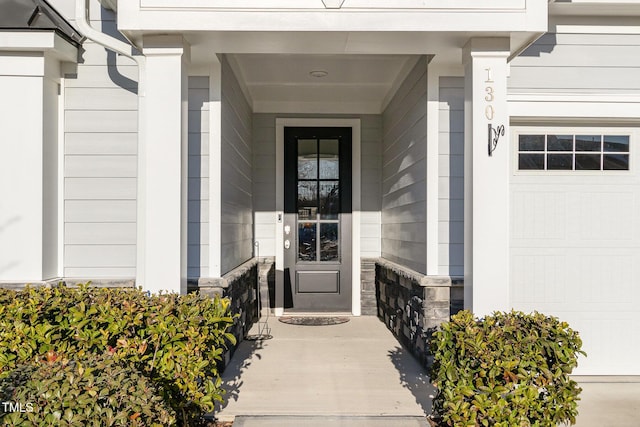 entrance to property with a garage and stone siding