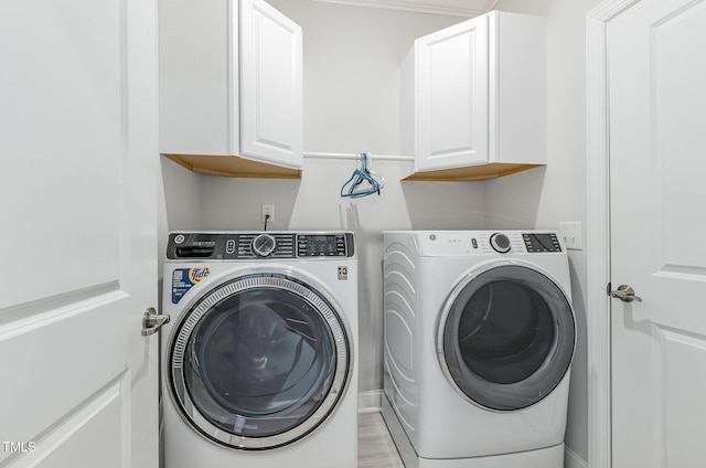 washroom featuring cabinet space and washing machine and clothes dryer