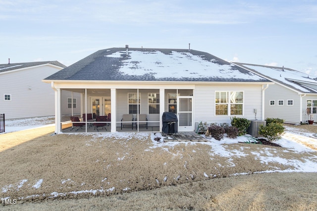 view of front of property with central AC and a sunroom