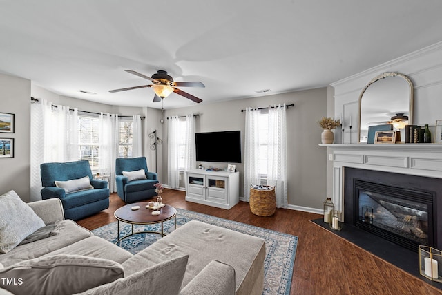 living room with a ceiling fan, healthy amount of natural light, wood finished floors, and a fireplace