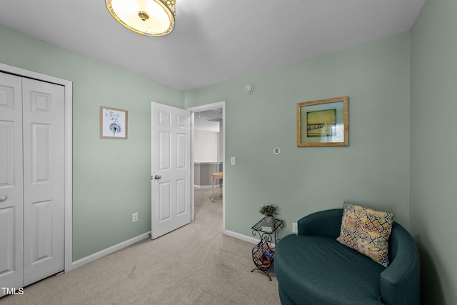 sitting room featuring light colored carpet and baseboards