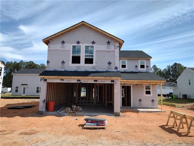 back of house featuring a patio, roof with shingles, and an attached garage