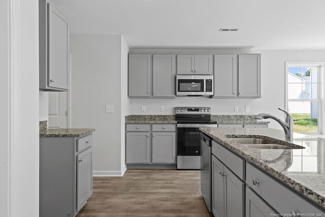 814 Tori Dr, Spring Lake, NC 28390 - kitchen with appliances with stainless steel finishes, a sink, gray cabinetry, and wood finished floors