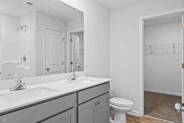 814 Tori Dr, Spring Lake, NC 28390 - full bath featuring double vanity, toilet, a spacious closet, and wood finished floors