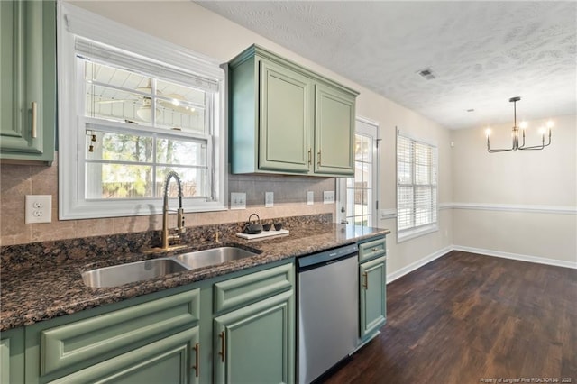 kitchen with decorative backsplash, green cabinetry, dishwasher, hanging light fixtures, and a sink