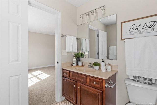 bathroom with toilet, baseboards, and vanity