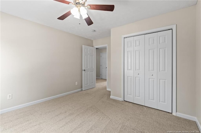 unfurnished bedroom featuring baseboards, a closet, a ceiling fan, and light colored carpet