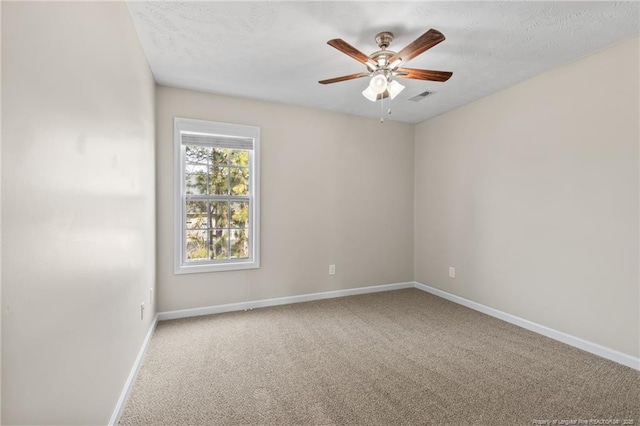 spare room with ceiling fan, a textured ceiling, carpet flooring, visible vents, and baseboards