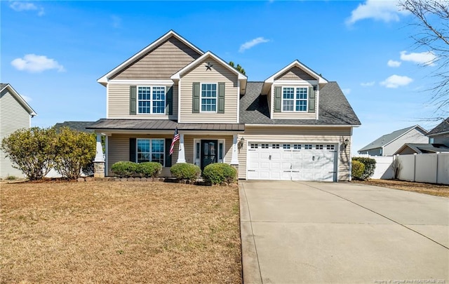 craftsman inspired home with a porch, concrete driveway, a front lawn, and fence