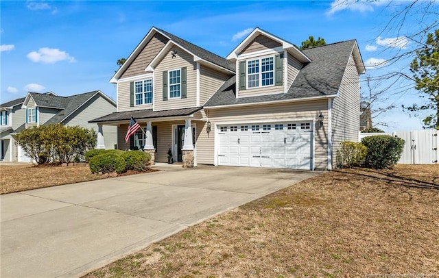 view of front of home with fence, concrete driveway, a porch, and a front lawn