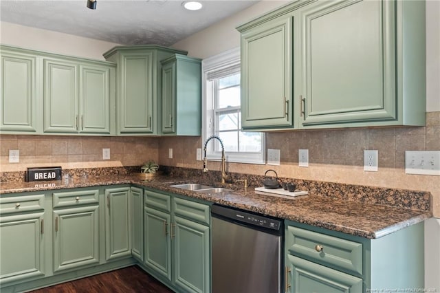 kitchen with a sink, green cabinetry, dishwasher, and backsplash