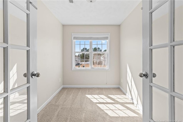 unfurnished room featuring baseboards and light carpet