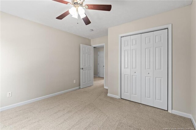 unfurnished bedroom featuring a closet, baseboards, a ceiling fan, and carpet floors