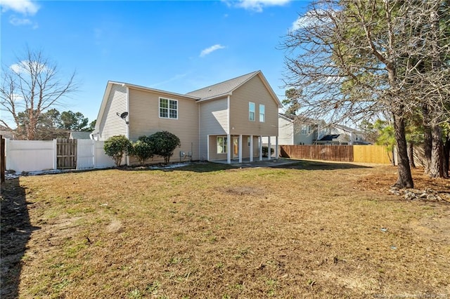 rear view of house featuring a patio, a yard, and a fenced backyard