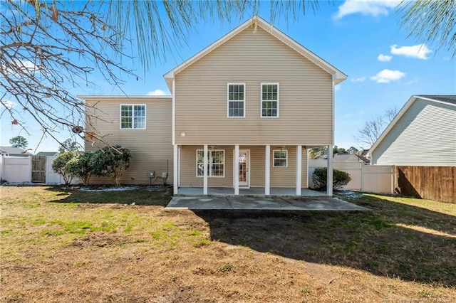 rear view of property featuring a yard, a patio area, and a fenced backyard