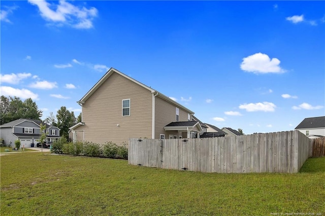 view of side of home with fence and a yard