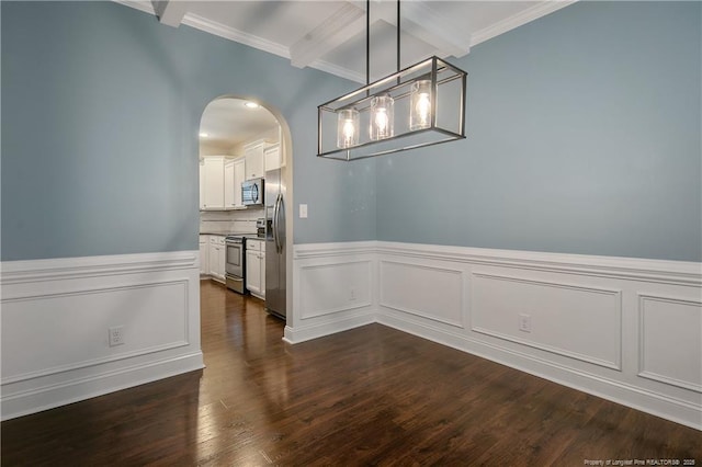 unfurnished dining area with dark wood-style floors, arched walkways, beam ceiling, ornamental molding, and wainscoting