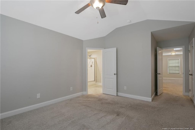 unfurnished bedroom with light carpet, ceiling fan, baseboards, and vaulted ceiling