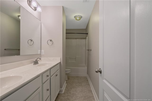 full bathroom featuring double vanity, a sink, toilet, and baseboards