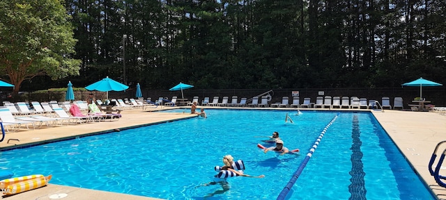 pool with a patio area and fence