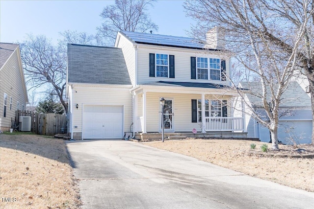 traditional home with driveway, solar panels, an attached garage, covered porch, and central AC